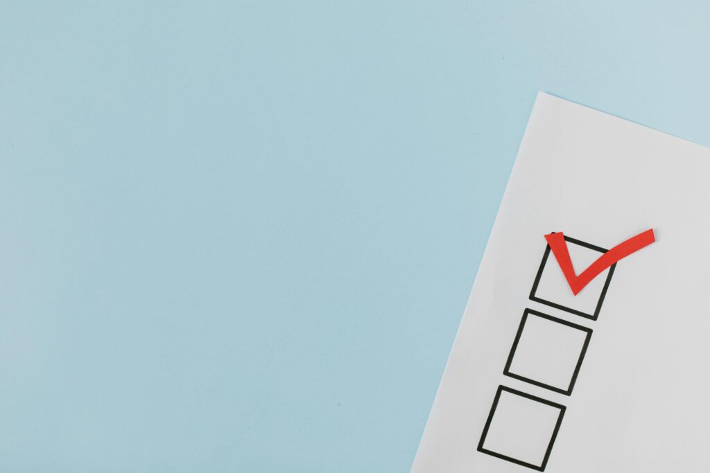 pexels-photo-8850709-8850709 A checklist with a red checkmark symbolizing a completed task on a pastel blue background.